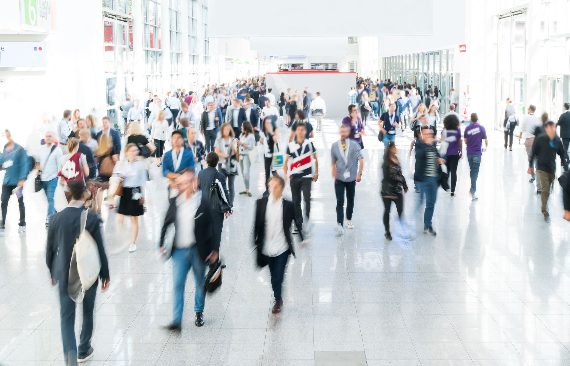 Besucherinnen und Besucher im Foyer einer Messehalle